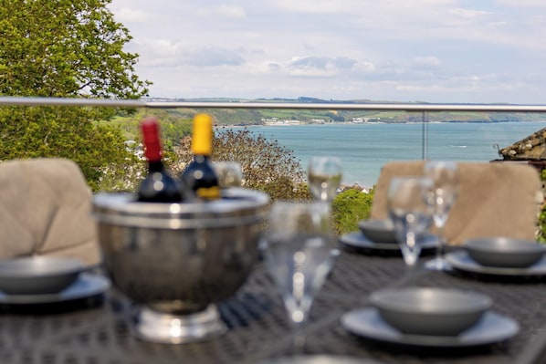 Savor a meal with a breathtaking view of the sea and distant land from this dining table.