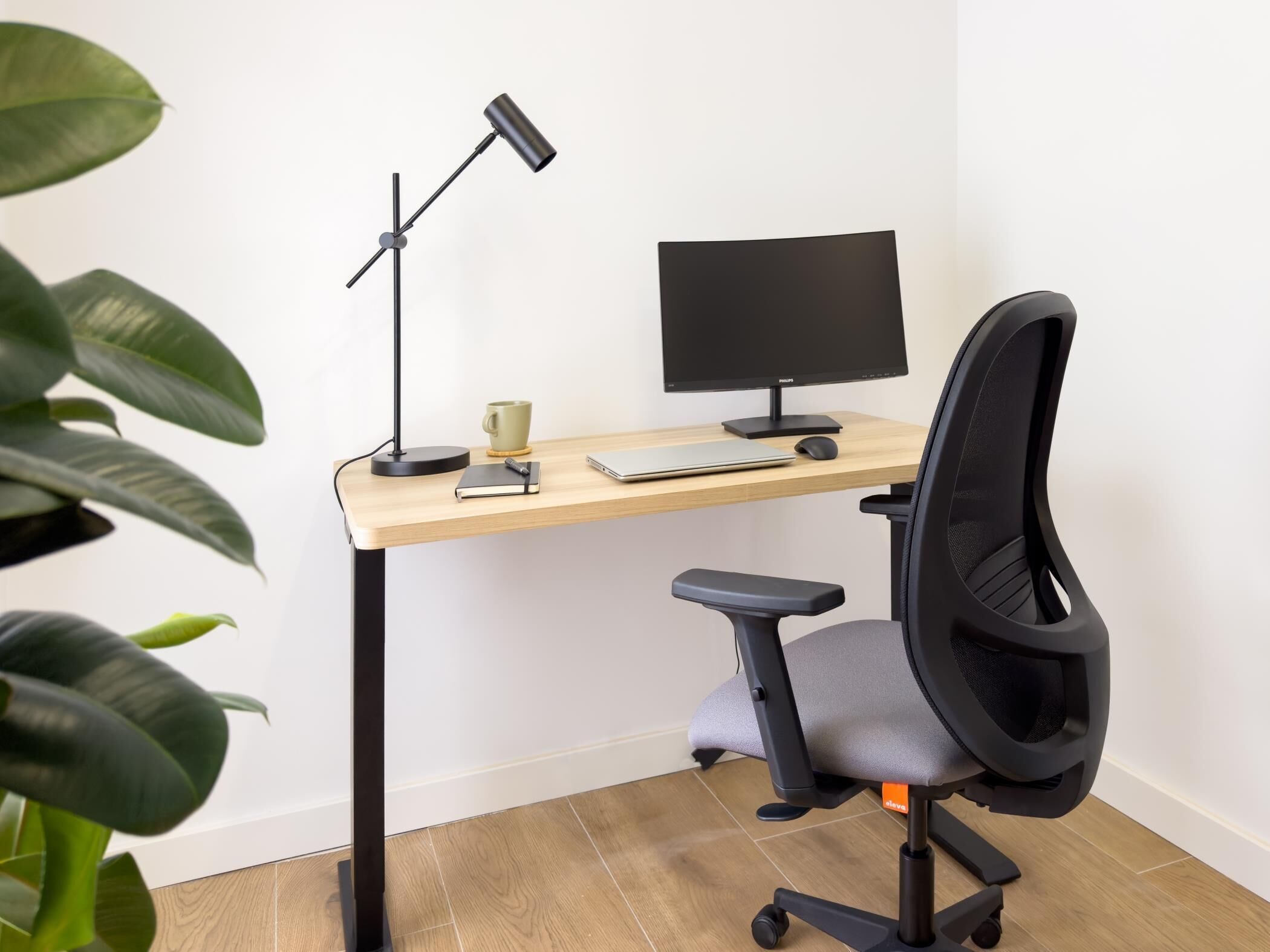 A modern office desk with a computer monitor, keyboard, and mouse.