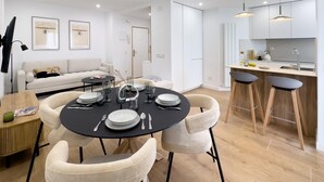 A modern apartment with a dining area, kitchen, and living space.