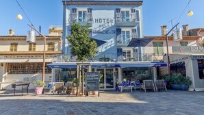 Een hotel met terras en een bord.