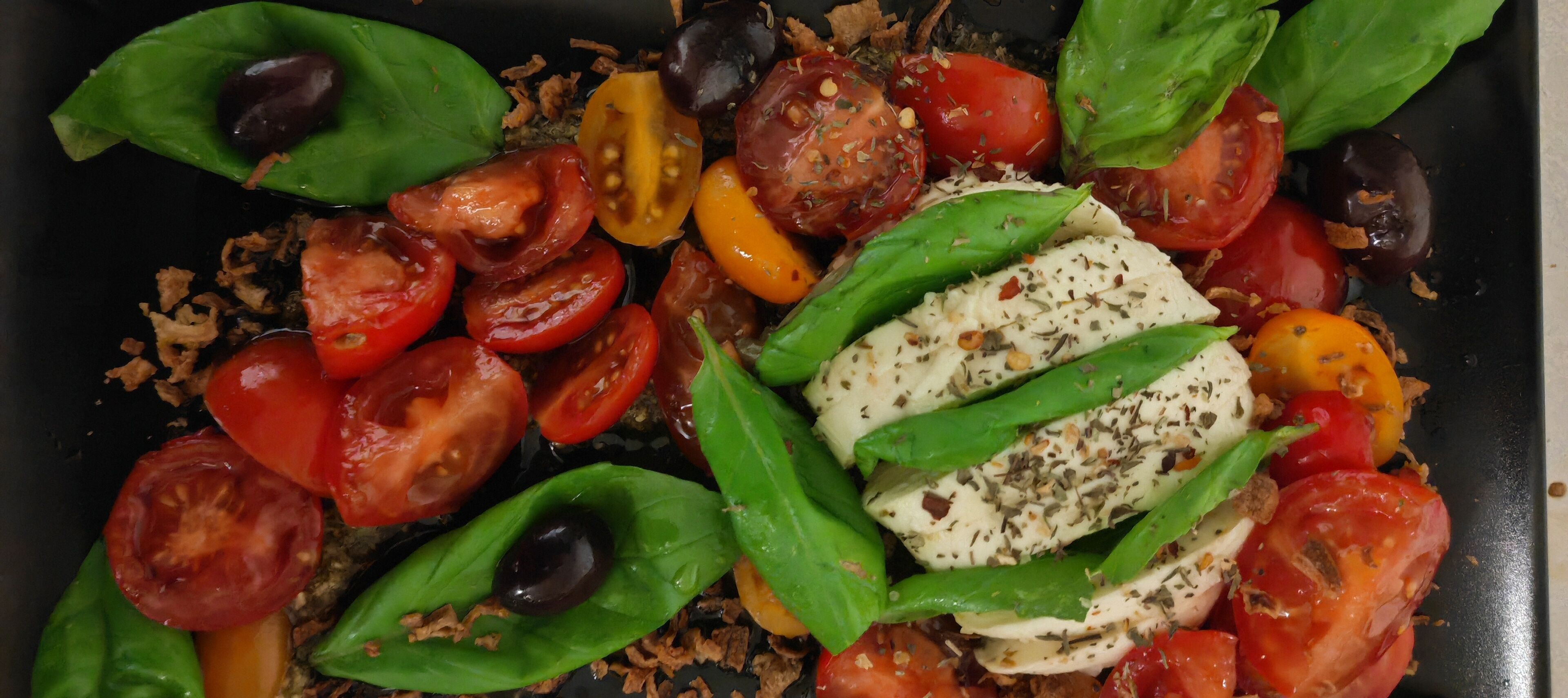 A close-up of a dish with tomatoes, basil, and mozzarella cheese.
