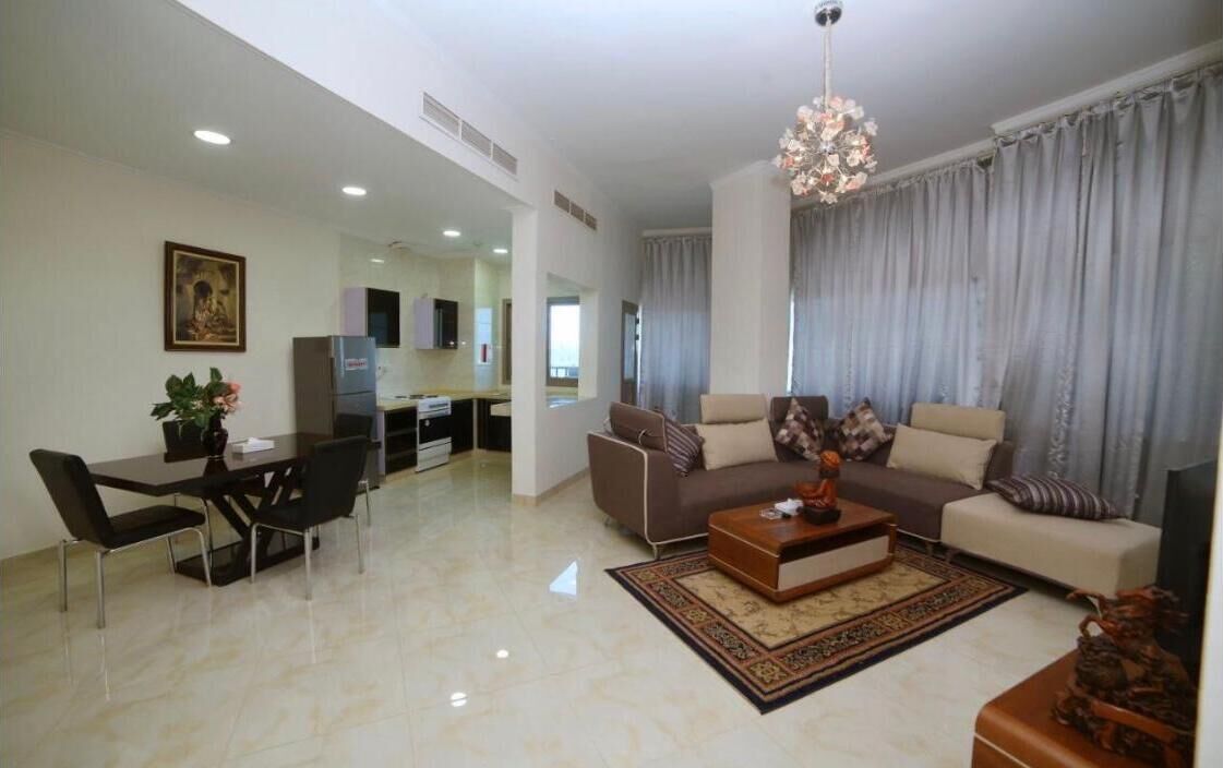 A spacious living room with a sofa, coffee table, and dining area.