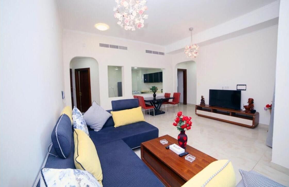 A modern living room with a sectional sofa, a coffee table, and a TV stand.