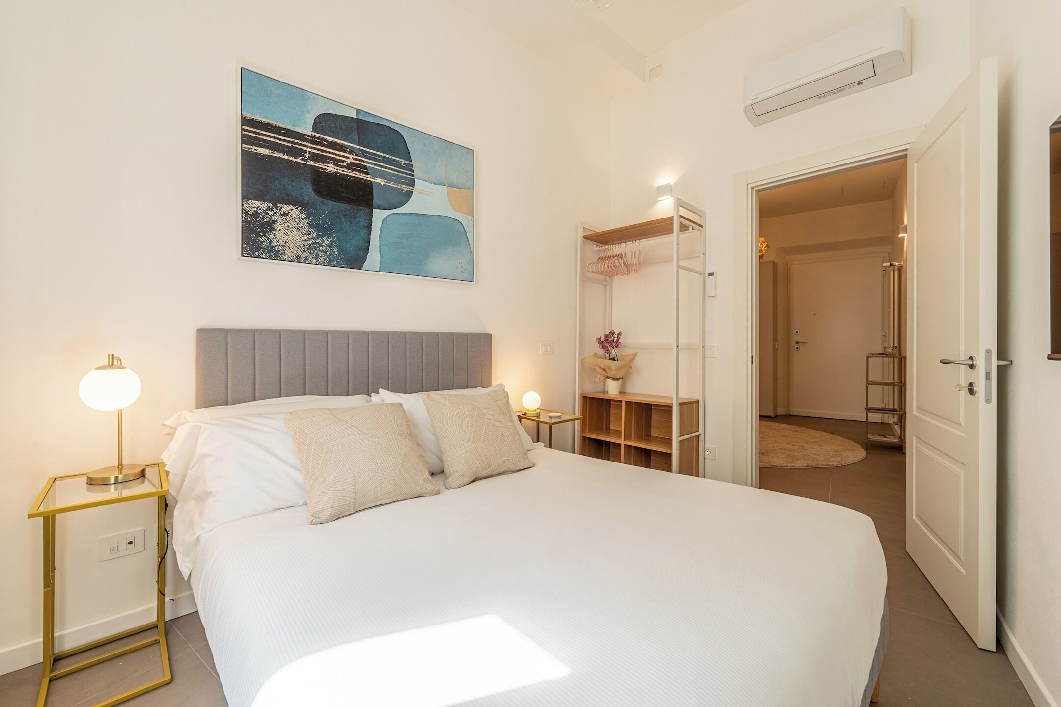 Ein Schlafzimmer mit Bett, Nachttischen, einem Kleiderschrank und einem Bild an der Wand.