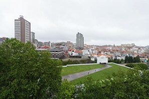 A cityscape with a mix of residential and commercial buildings, a prominent white building with a dome, and a large green park area.