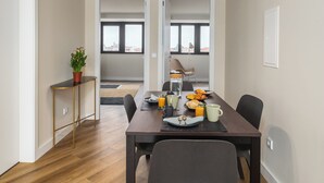 Un comedor moderno con una mesa de madera, sillas y una planta en maceta.