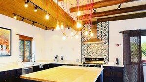 Una cocina moderna con una isla grande, iluminación colgante y un salpicadero con diseño.