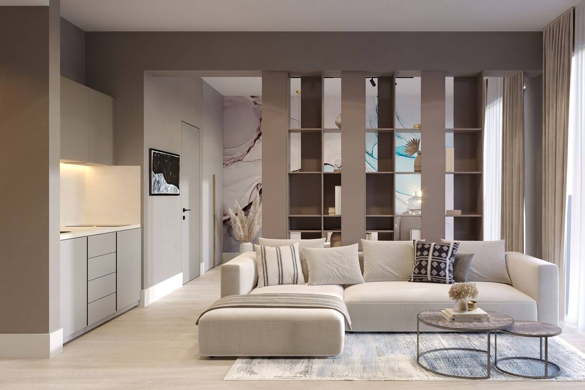 Una sala de estar moderna con un sofá, un reposapiés y una mesa de centro, una estantería y un ventanal con cortinas.