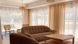 A modern living room with a brown sofa, a wooden coffee table, and wicker pendant lights. - Villa Las Palmeras in Alhaurin de la Torre (Alhaurin de la Torre)