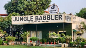 A building with a sign that reads "Jungle Babbler NH-48, Dharuhera" and "Haryana Tourism".