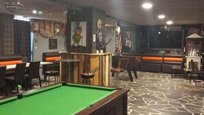 A billiards table, seating areas, and a bar area with stools and a counter. - Hôtel Restaurant Le Montlo 48 (Mont Lozere et Goulet)