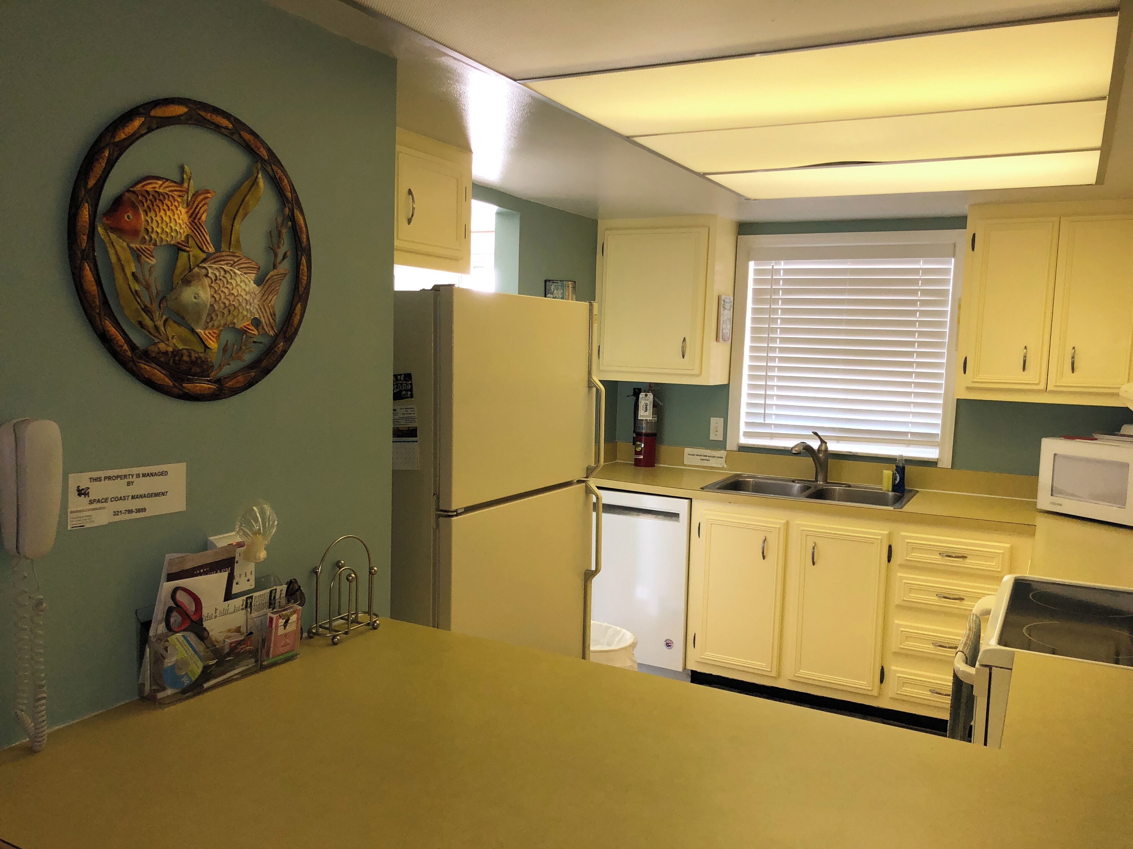 A compact kitchen with basic amenities, including a refrigerator, microwave, and sink.