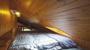 A small attic bedroom with wooden walls and a sloped ceiling. - 100m from ski slopes, view village, balcony, fireplace or stove, tv, ski locker, 34m² (Champagny-en-Vanoise)