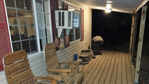 A wooden deck with outdoor furniture, a covered area, and a window with blinds. - Cabin stay close to state park (Spring Mills)