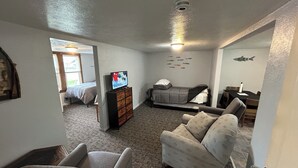 A compact living room with a sofa, a television, a bed, and a dining table. - Fishermen’s Denn, close to Lake Erie Islands, boat ramps, ferries, and marinas (Port Clinton)