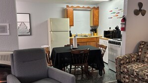 A compact kitchen with a refrigerator, stove, microwave, and wooden cabinets. - Fishermen’s Denn-Marblehead and Port Clinton  vacation area (Port Clinton)