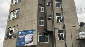 A multi-story building with a large advertisement for a guest house. - SIMPLE GUEST HOUSE (Addis Ababa)