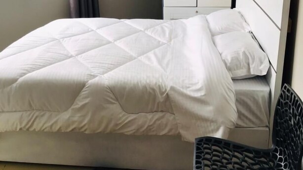 A hotel room with a bed, a wardrobe, a chair, and a window with curtains. - SIMPLE GUEST HOUSE (Addis Ababa)
