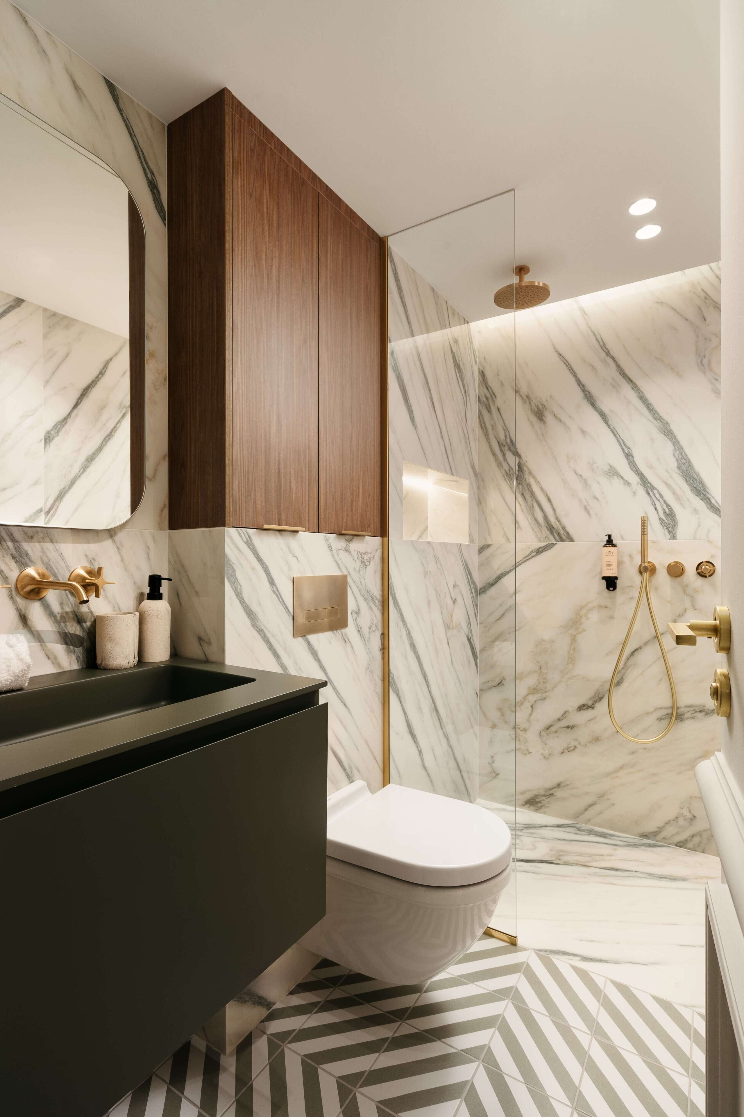 Une salle de bain moderne avec une douche en marbre, des toilettes et un meuble-lavabo avec un évier.
