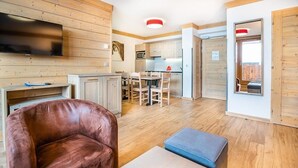 A modern interior with a wooden floor, a leather sofa, a dining table, and a kitchen area. - Wifi, ski-in/ski-out & foot of the slopes, 3rd floor, view mountain, fitness, swimming pool, sauna (La Rosière Montvalezan)