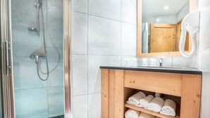 A bathroom with a glass-enclosed shower, a wooden vanity with towels, and a mirror above the sink. - Wifi, ski-in/ski-out & foot of the slopes, 2nd floor, terrace, tv, ski locker, 65m², Tignes (Tignes)