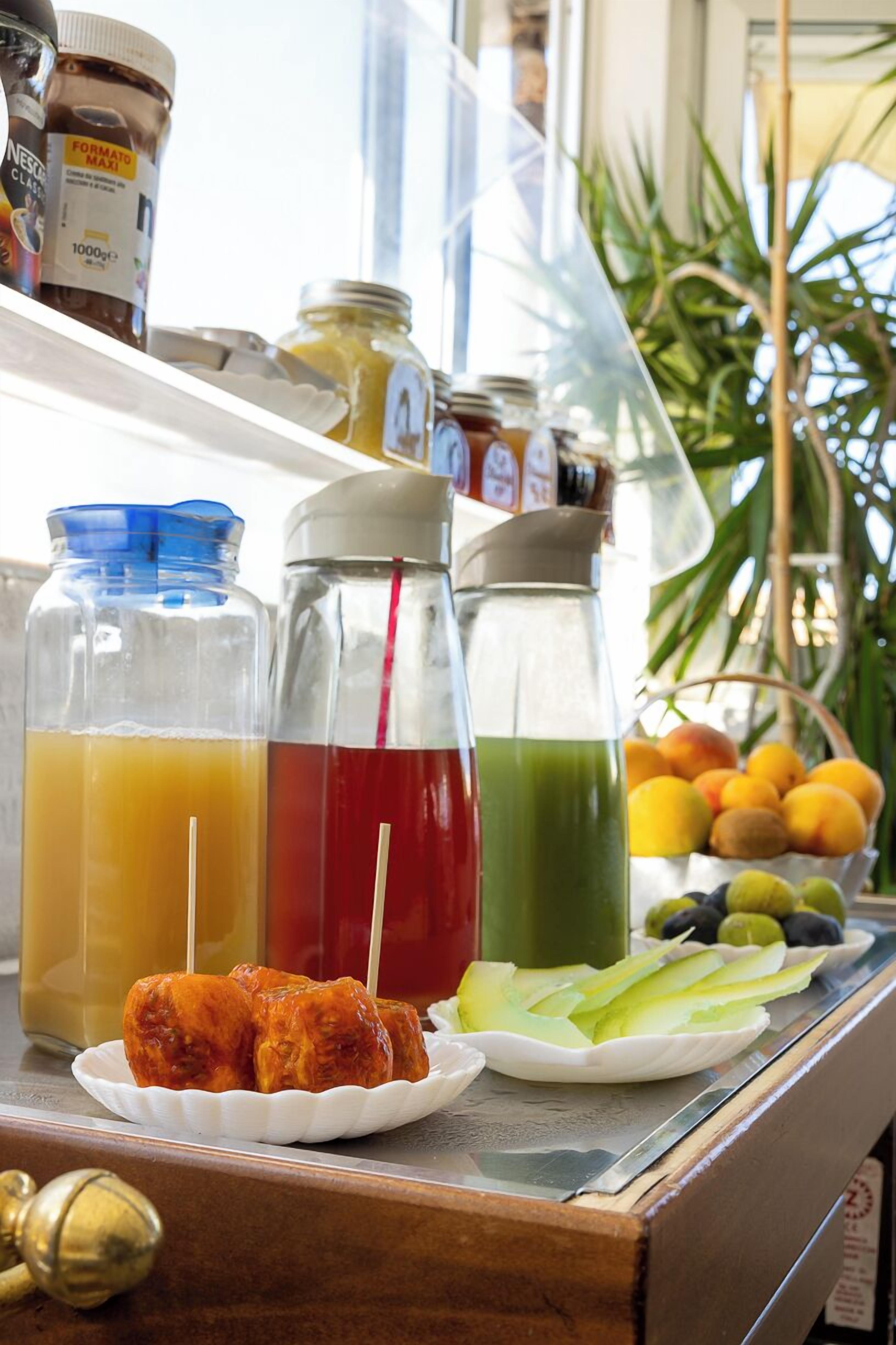 A bar area with various beverages in bottles and glasses, a plate with food, and a basket of fruits.