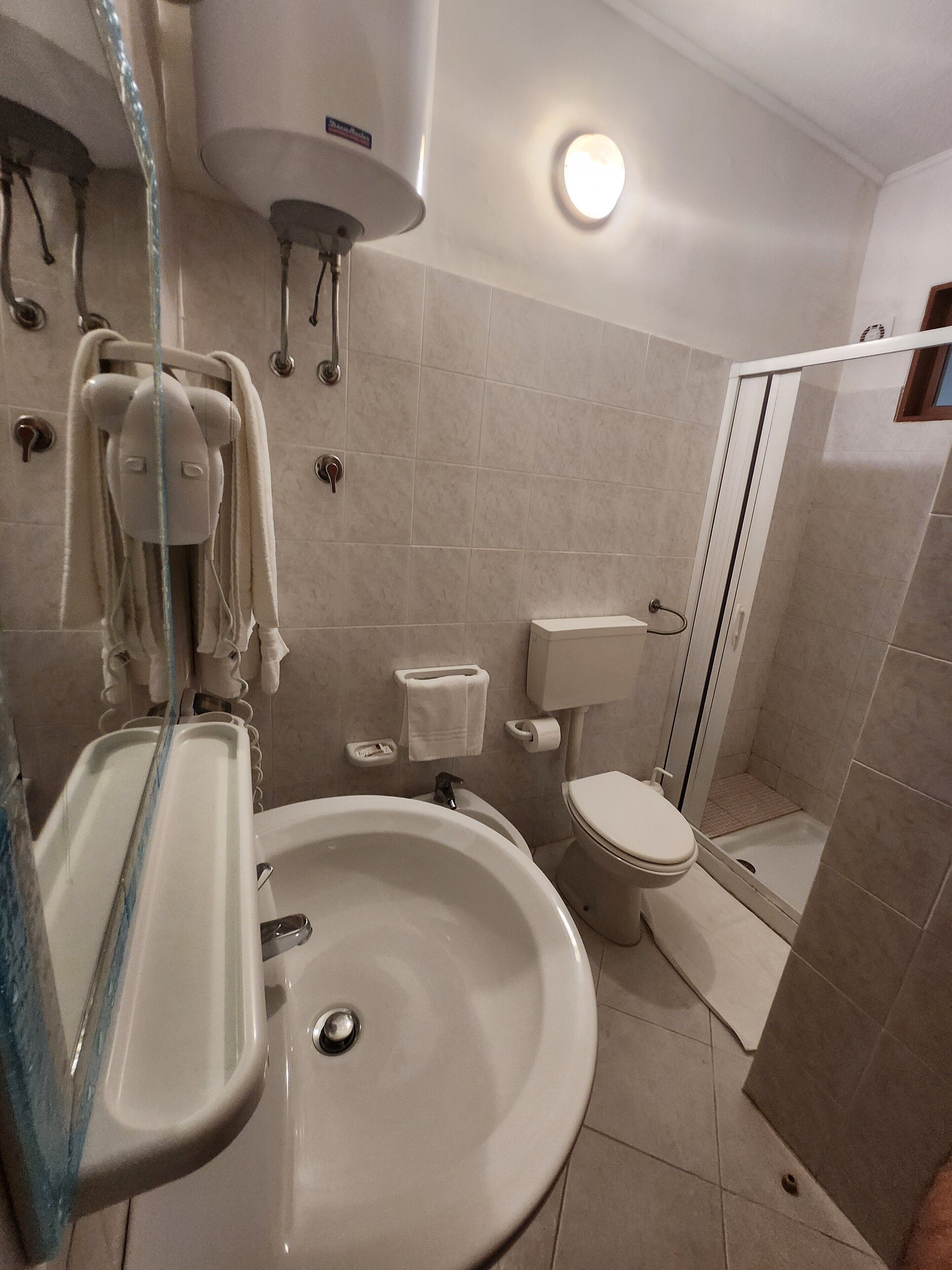 Une salle de bain avec un lavabo, des toilettes et une douche.