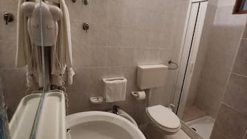 Une salle de bain avec un lavabo, des toilettes et une douche.