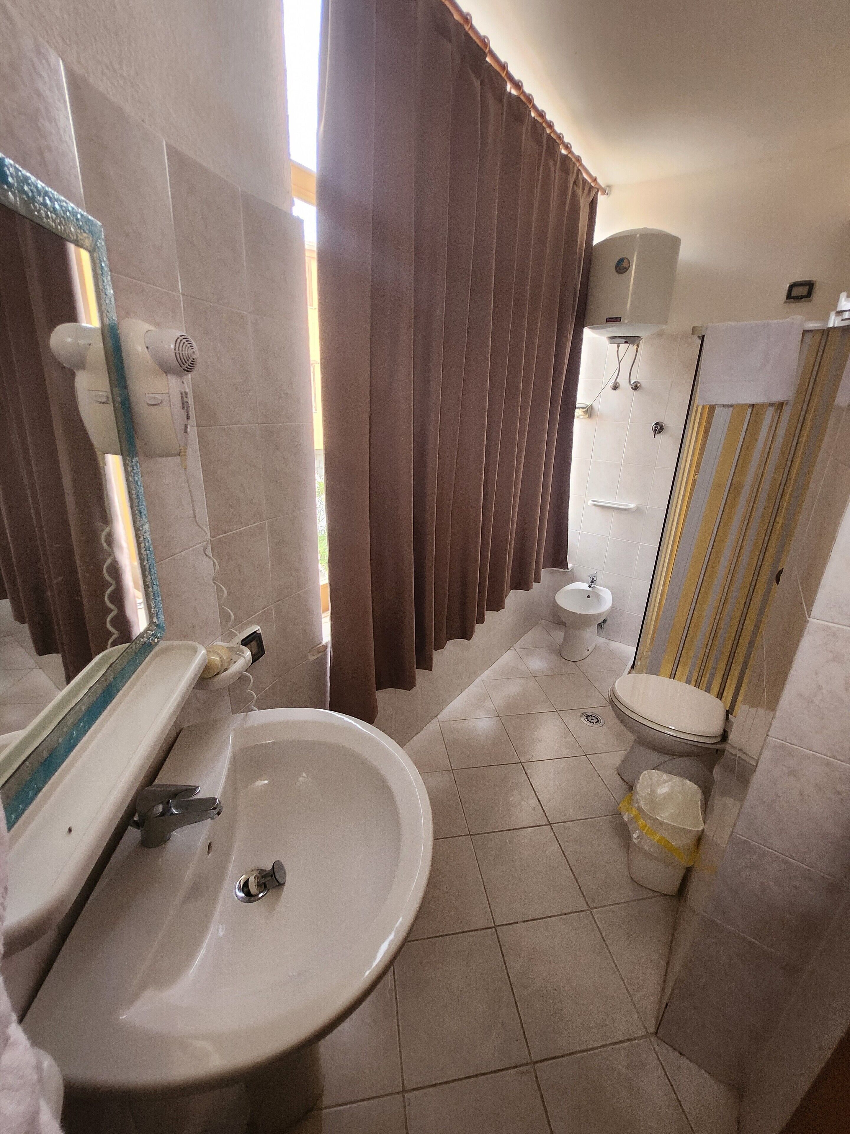 Un baño con lavamanos, inodoro y zona de ducha.
