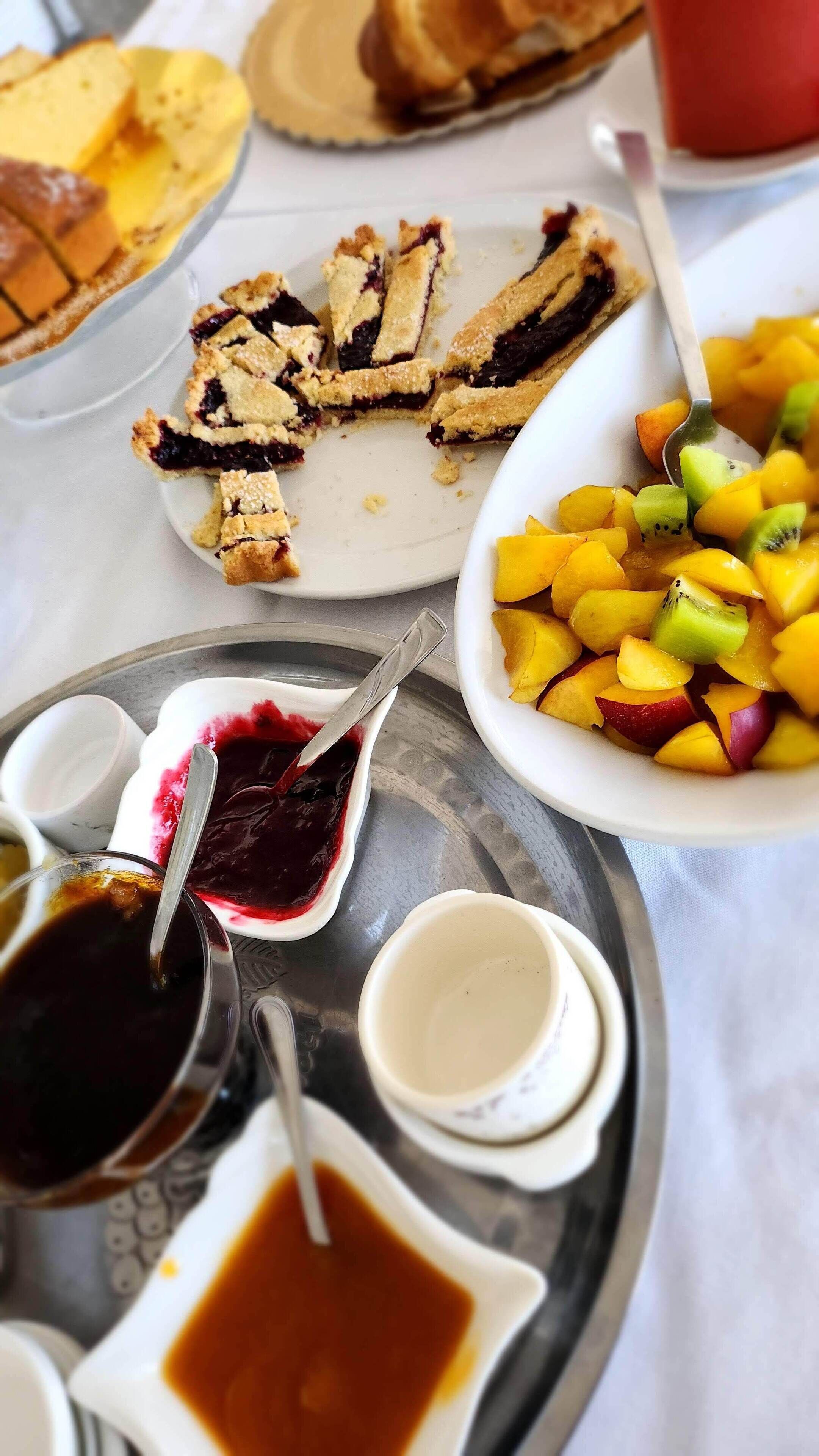 A tray with a pie, fruit salad, and various sauces.