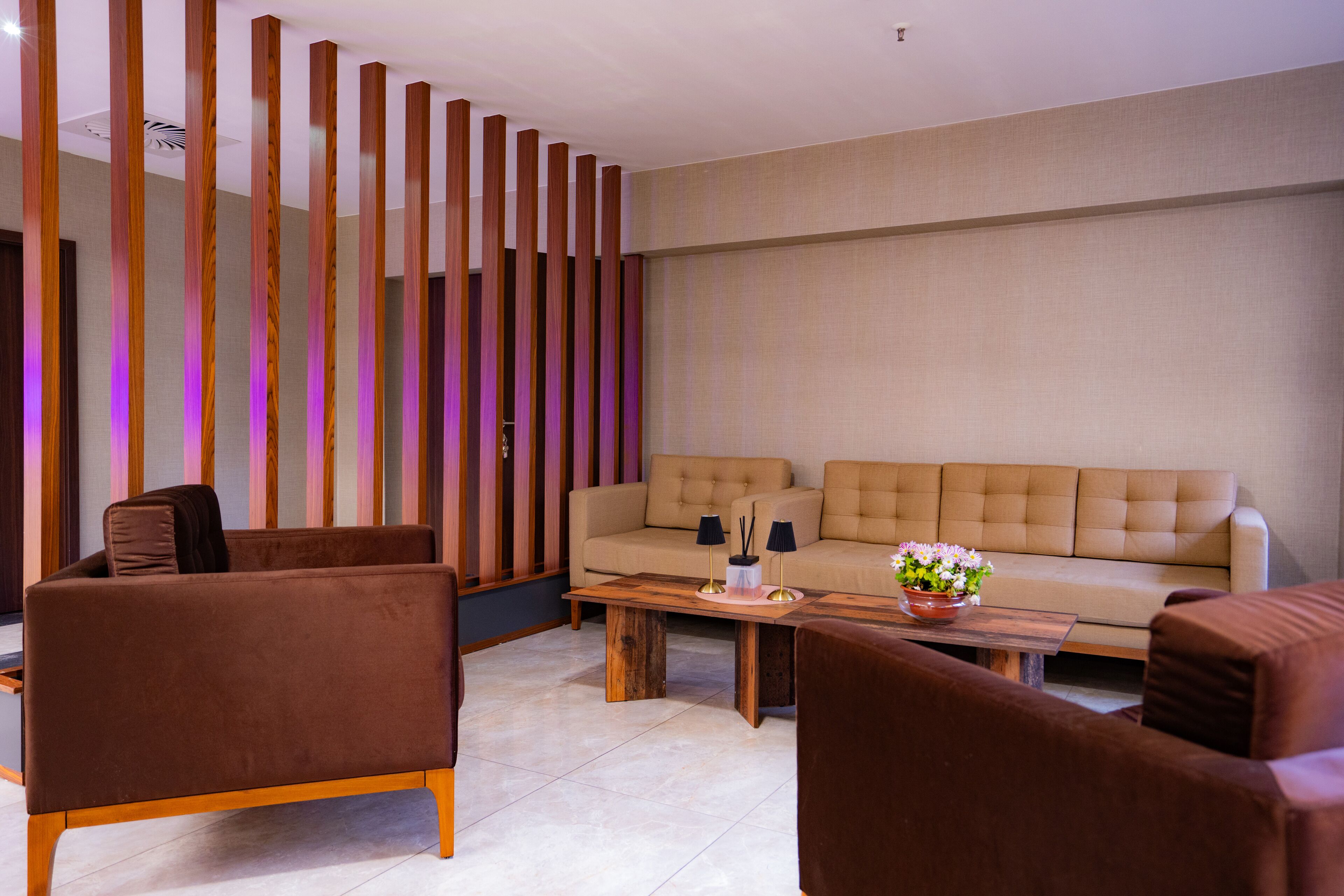 A modern living room with a beige sofa, brown armchairs, and a wooden coffee table.