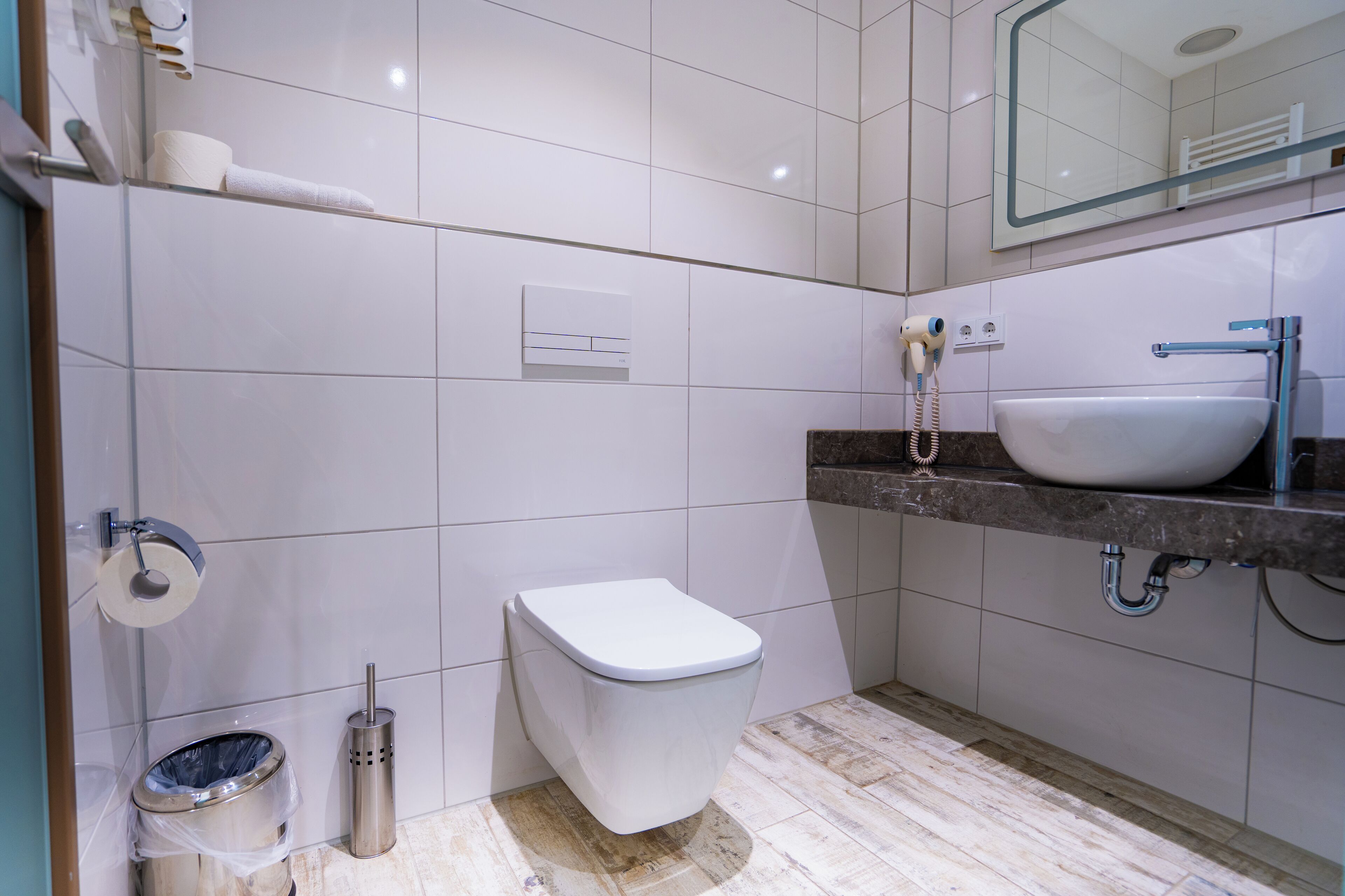 A modern bathroom with a toilet, sink, and shower.
