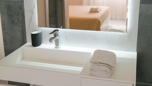 A bathroom with a white sink, a mirror, and a towel. - Aphrodite House (Pompei)