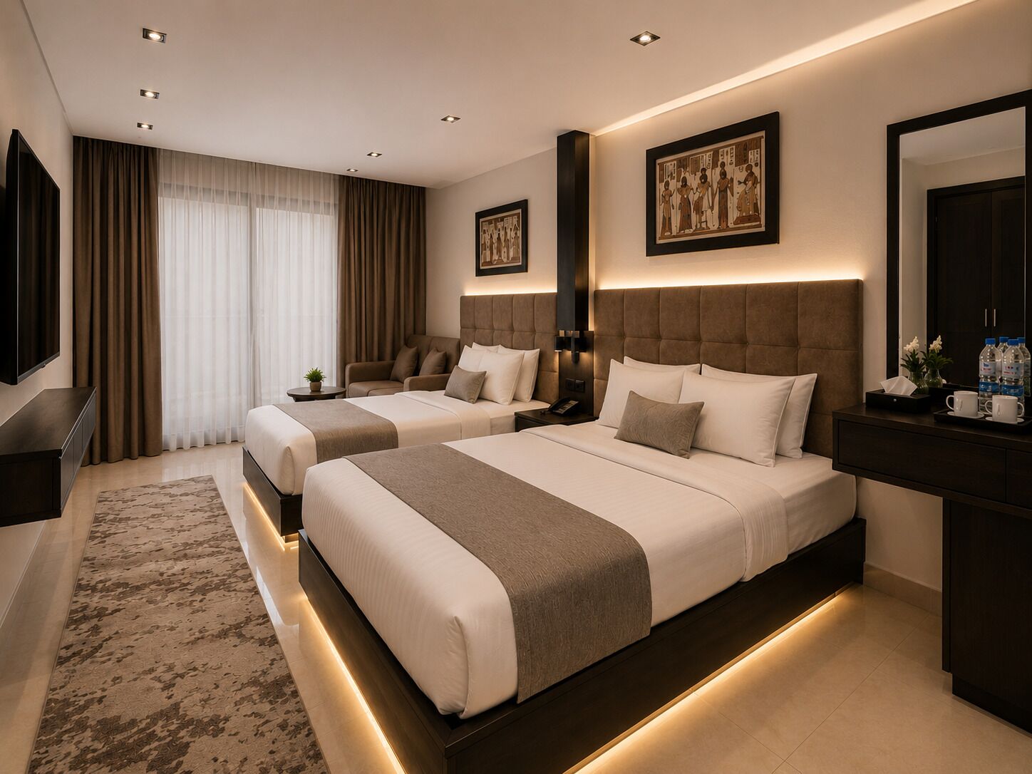 A hotel room with two beds, a TV, a bedside table, a nightstand, and a large mirror.