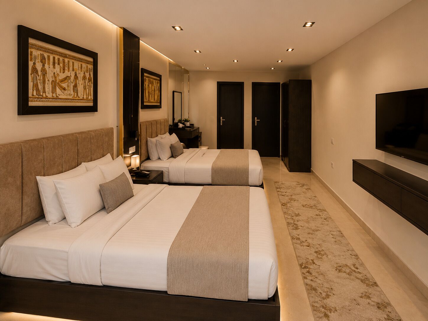 A hotel room with two beds, a TV, a mirror, and artwork on the wall.