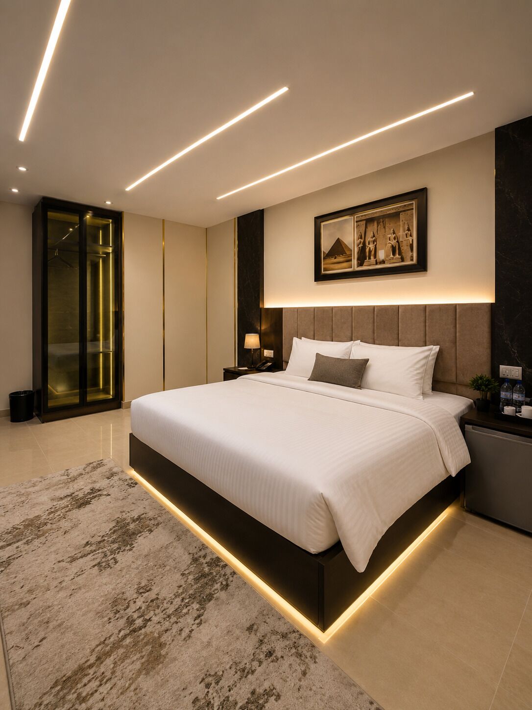 A modern bedroom with a large bed, recessed lighting, a framed picture on the wall, and a glass elevator.