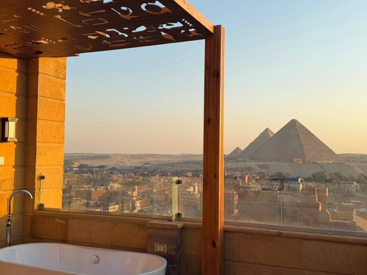 A bathroom with a bathtub and a view of the pyramids.