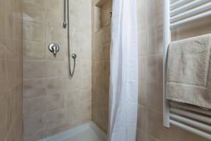 Eine Dusche mit Handbrause und Armaturen an der Wand.