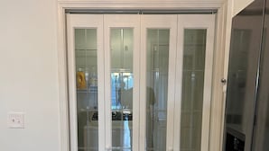 Una puerta blanca con paneles de vidrio que da a una cocina.