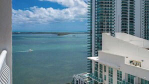 A high-rise hotel with a view of the ocean and a distant island. - Curated Sky Abode: Ocean & City views, Sleeps 6 (Miami)