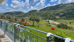 A balcony with a metal railing overlooking a green landscape with hills and a clear blue sky. - Family - sized villa , pet friendly , city and castle view with a big garden ! (Berat)