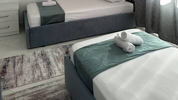 Una camera d'albergo moderna con un letto singolo, un comodino, un condizionatore d'aria e una finestra con tende.