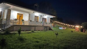 A two-story house with a balcony, a wooden door, and a small garden area. - Family - sized villa , pet friendly , city and castle view with a big garden ! (Berat)