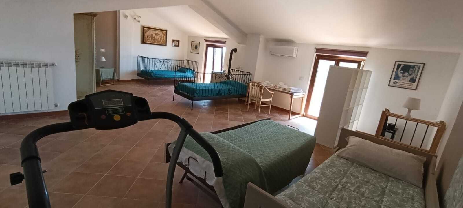 A spacious room with a bed, a chair, a desk, and a window.