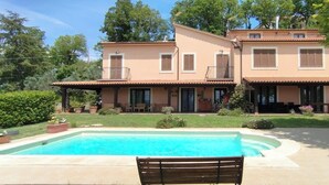 Une maison à deux étages avec une piscine et un espace patio.