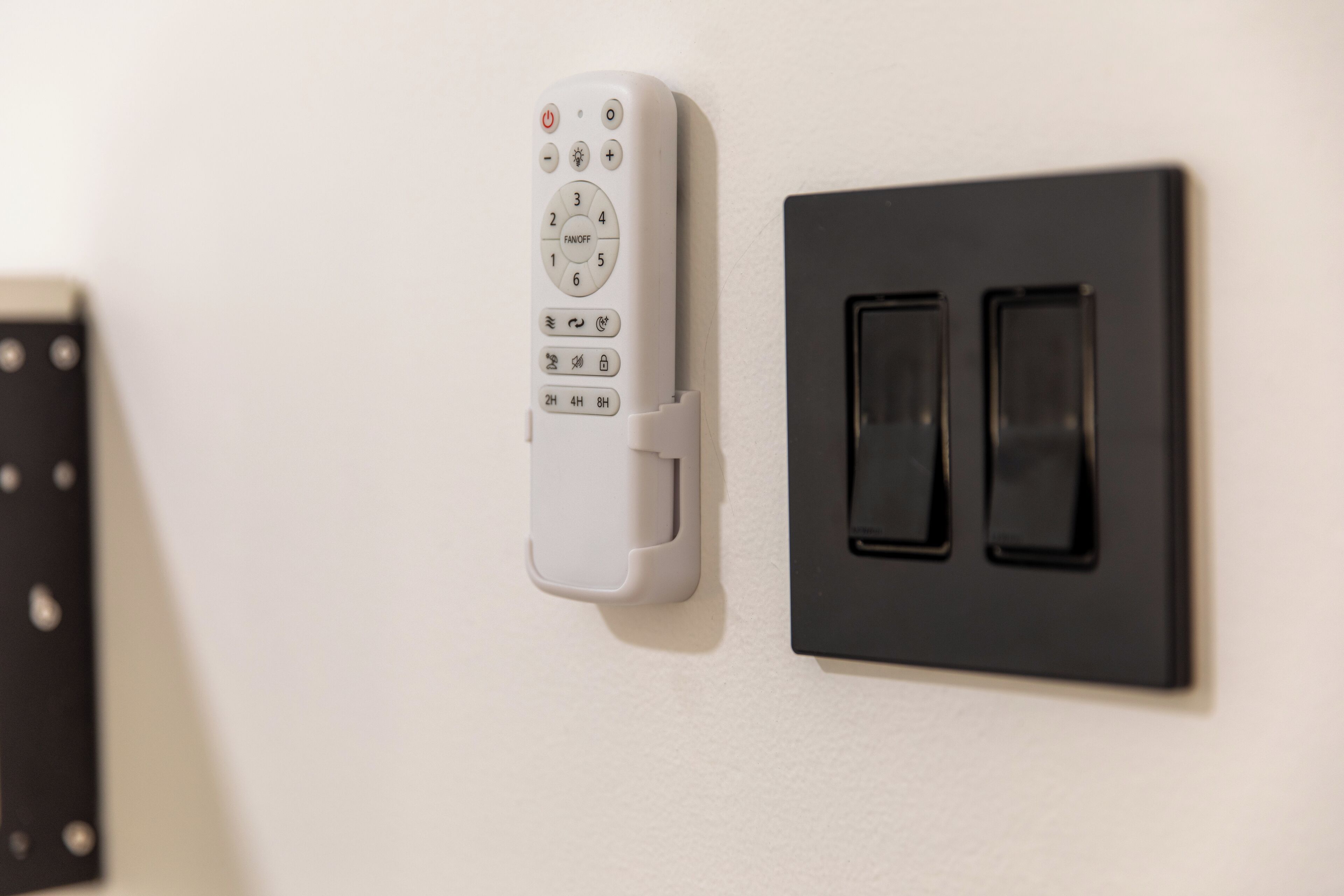 Un termostato montado en la pared y un control remoto.