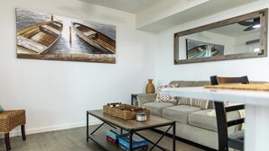 A living room with a sofa, coffee table, and artwork on the wall. - Romantic Waterfront Getaway
 1st Floor Deep Water Views (Beaufort)