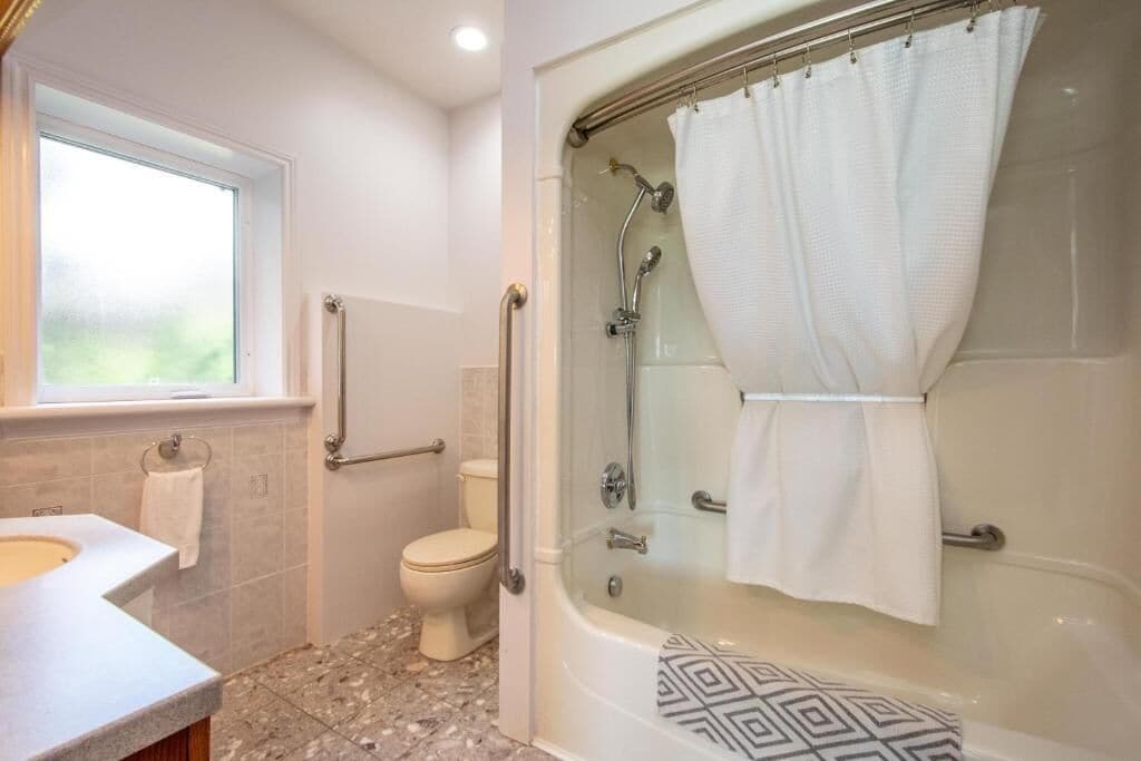 A bathroom with a shower, toilet, and sink.