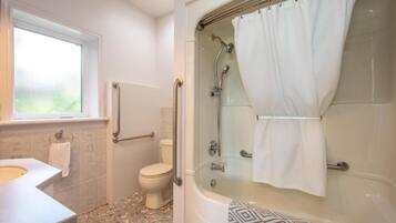 A bathroom with a shower, toilet, and sink.
