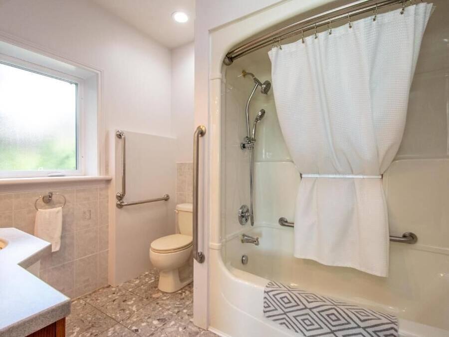 A bathroom with a shower, toilet, and sink.